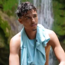 Man with towel near a waterfall outdoors
