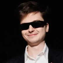 Smiling man wearing sunglasses and a suit