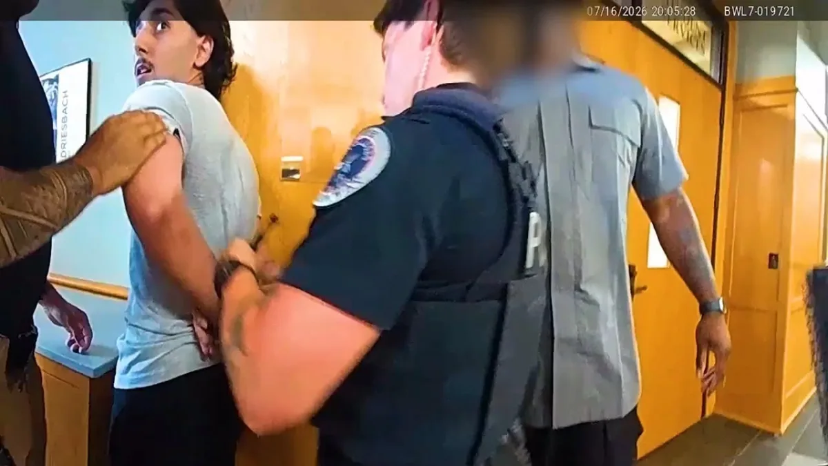Police officers detain man in hallway