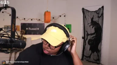 Streamer wearing headset and yellow cap in room