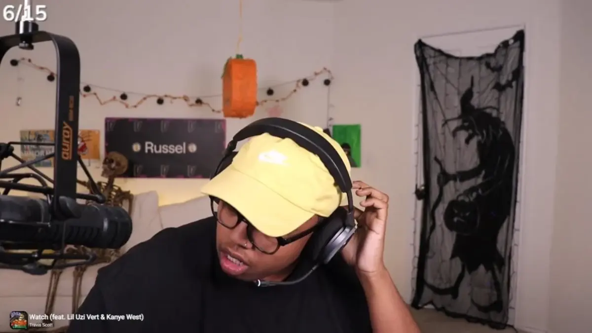 Streamer wearing headset and yellow cap in room