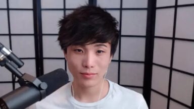 Person speaking into microphone with folding screen backdrop