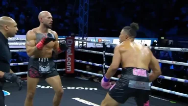 Two kickboxers fighting in a boxing ring