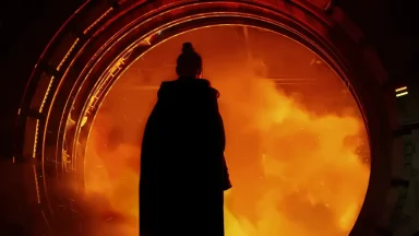 Silhouette facing fiery portal in dark scene