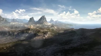 Mountainous coastal valley with castle under cloudy blue sky