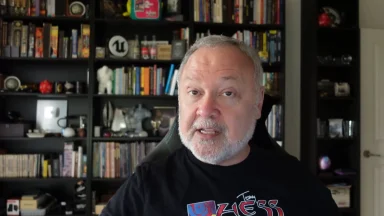 Person speaking in front of bookshelf background