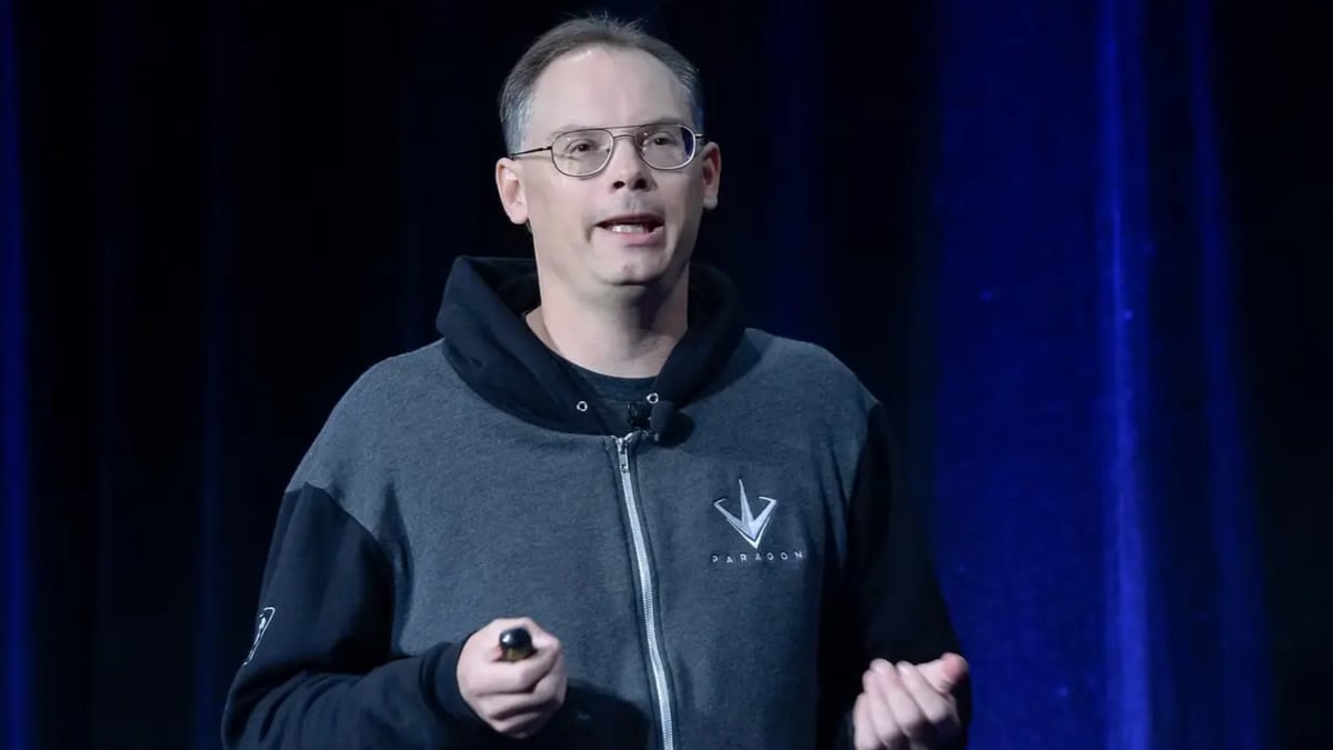 Man in Paragon hoodie speaking on blue-lit stage