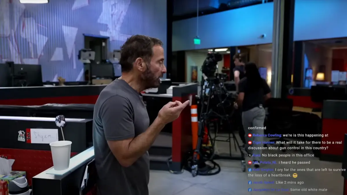 Man in office with camera setup, livestream comments visible.