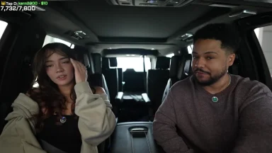 Two people sitting inside a car, talking.