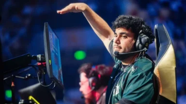 Esports player wearing headset raises hand at tournament