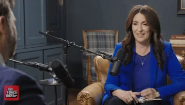 Woman in blue blazer speaking during podcast interview
