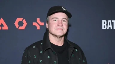 Man wearing a black jacket and cap at event