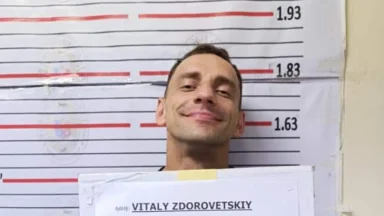 Man smiling in front of height chart.