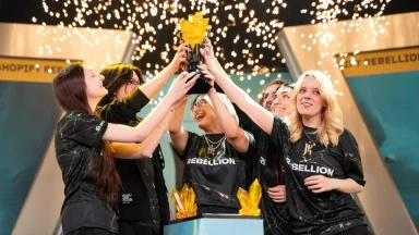 Esports team celebrating with championship trophy on stage