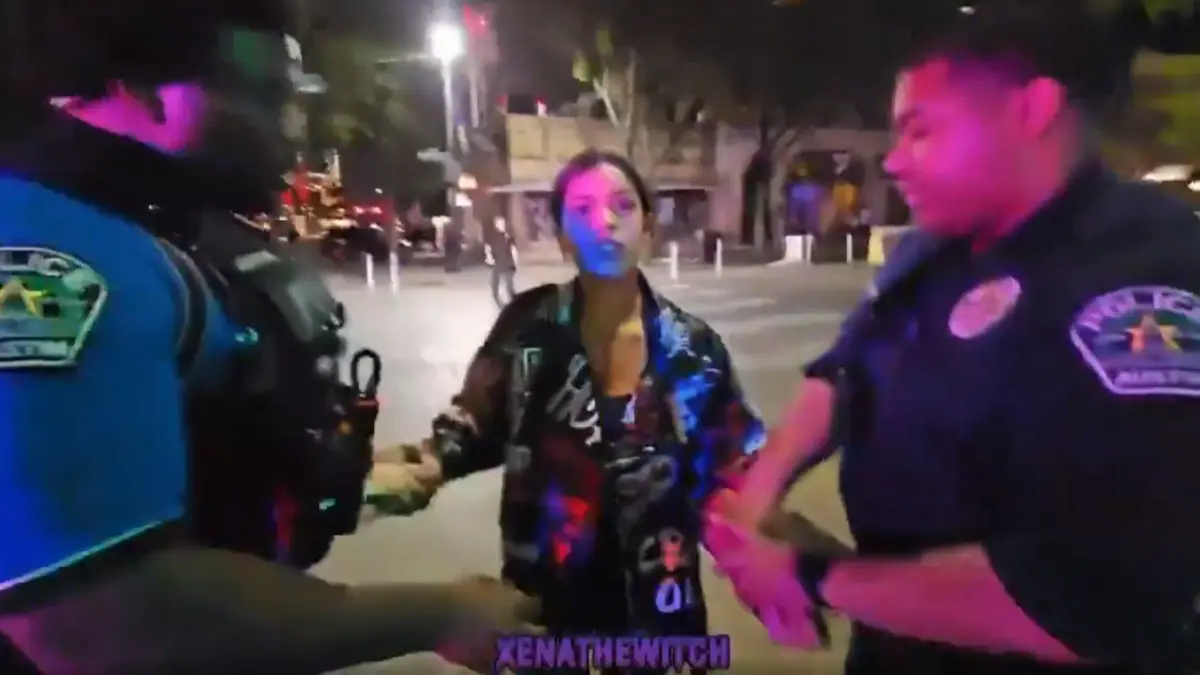 Police officers detaining woman at night on city street