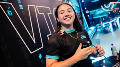 Smiling esports player holding mouse on stage