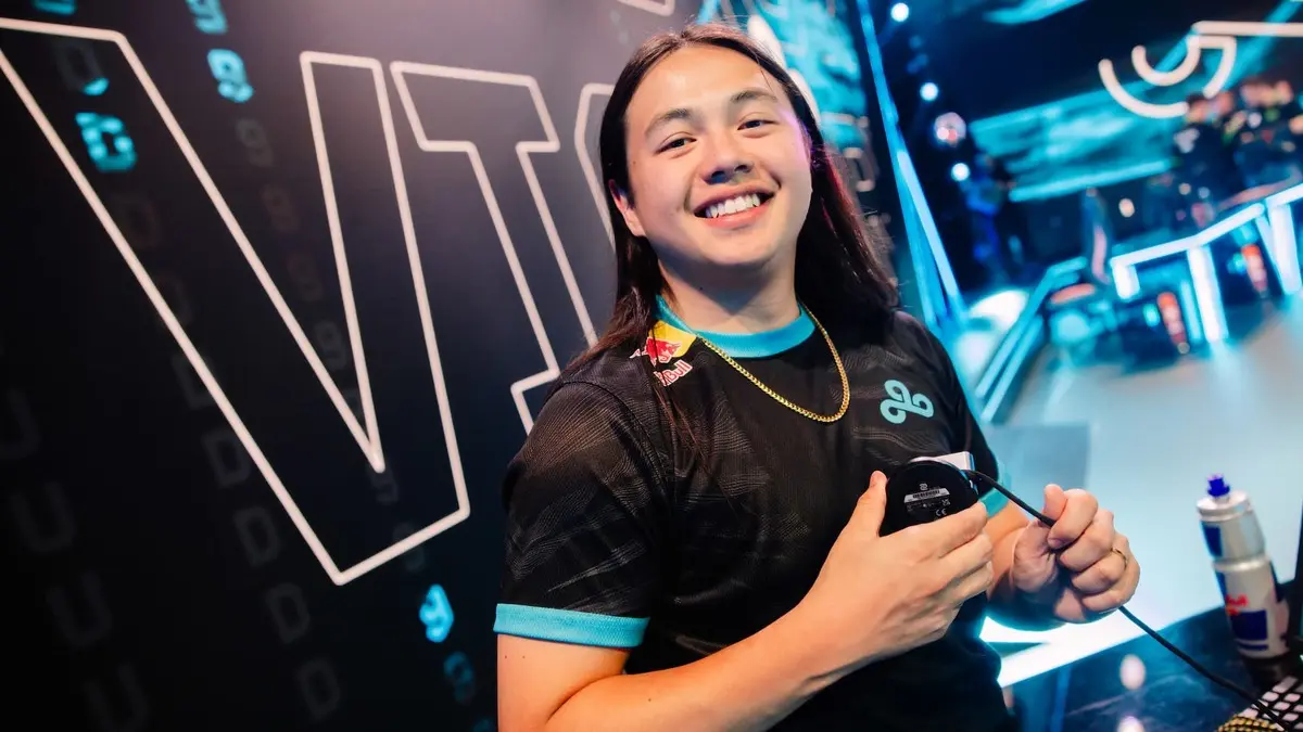 Smiling esports player holding mouse on stage