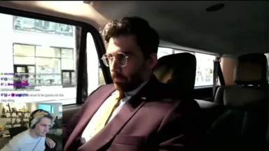 Man in suit sits in car during livestream